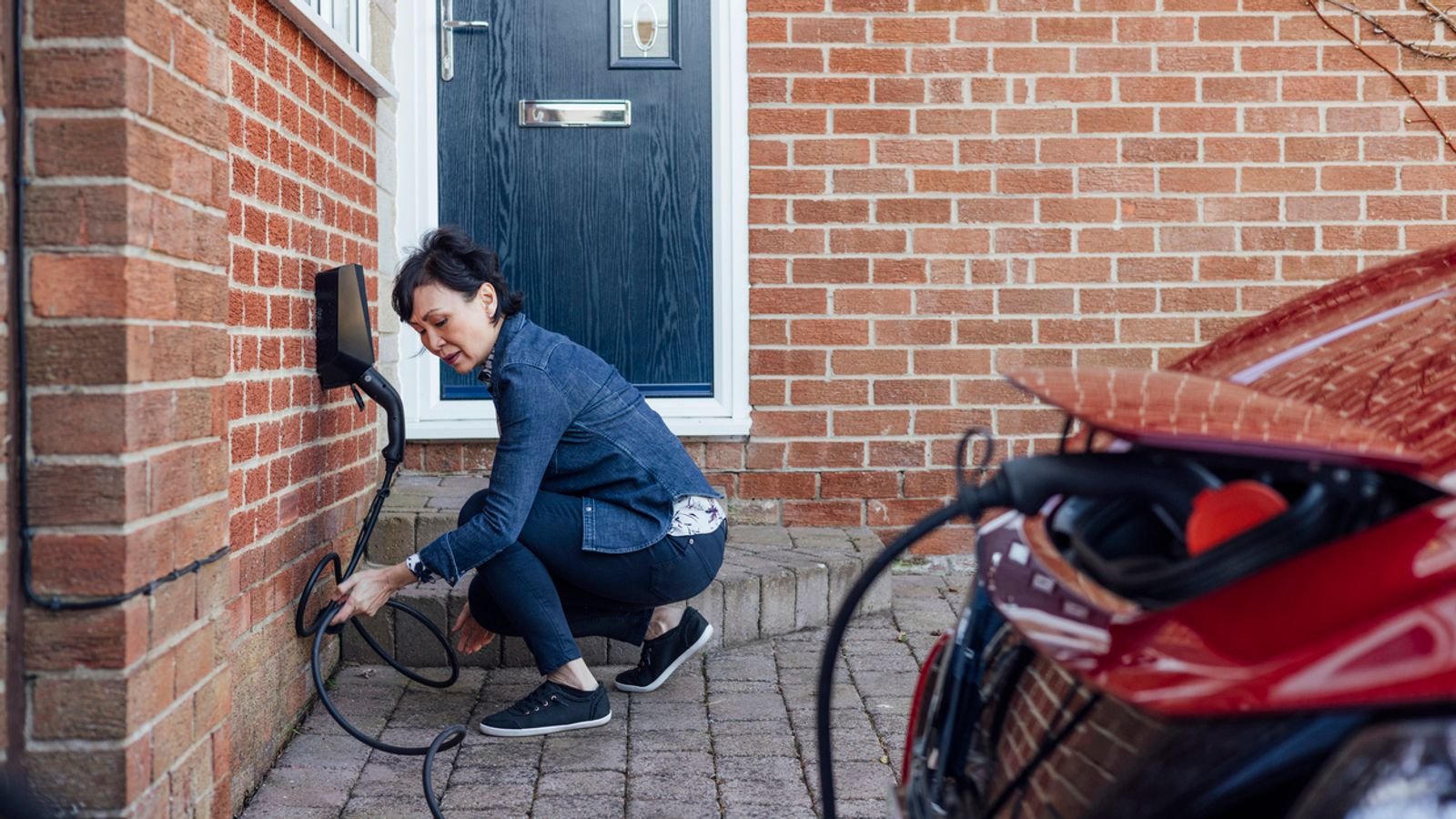 A woman charges her EV at home. File pic: iStock