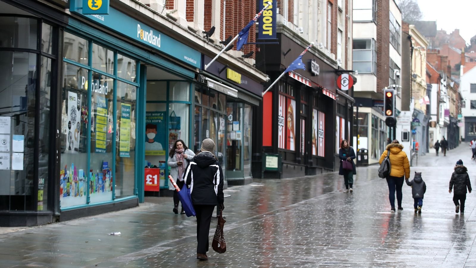 Shoppers walk past closed shops and Poundland in Lincoln city centre
