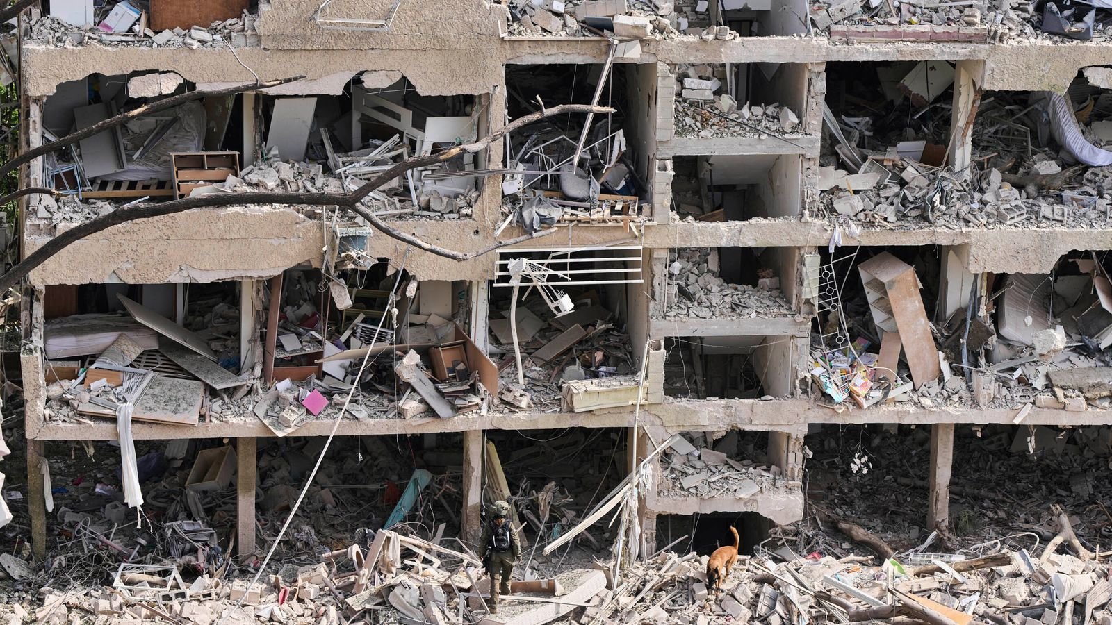 Rescue workers inspect the site of an Iranian missile strike in Tel Aviv, Israel on Sunday. Pic: AP