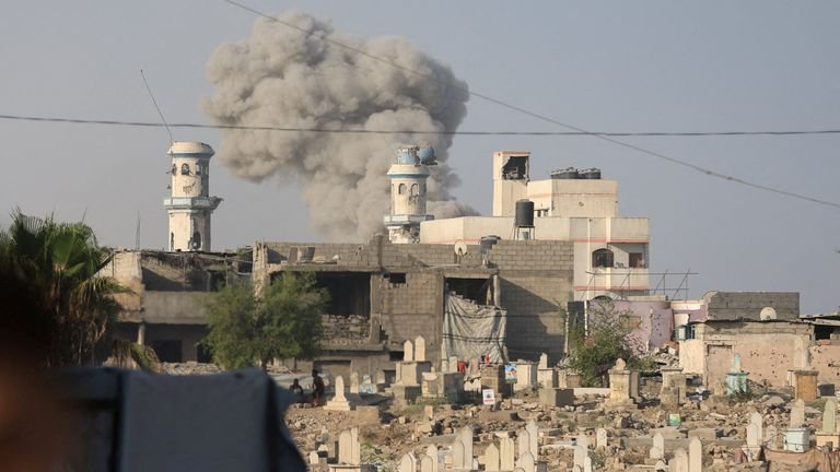 Tombstones of those killed in Gaza as smoke rises from further attacks near Gaza City in late-August. Pic: Reuters
