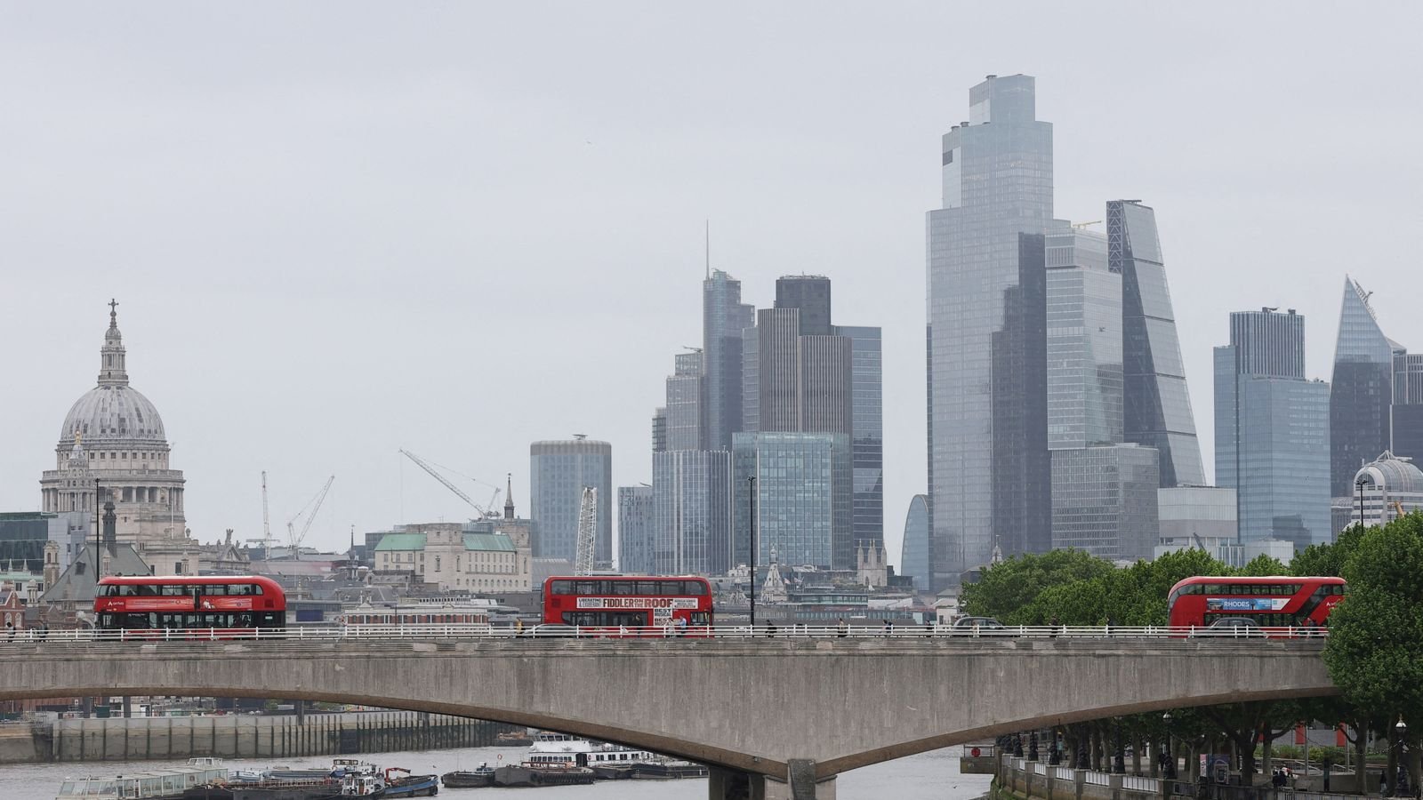 Buses cross Waterloo Bridge as skyscrapers in the City of London financial district, together with St. Paul’s Cathedral. Pic: Reuters
