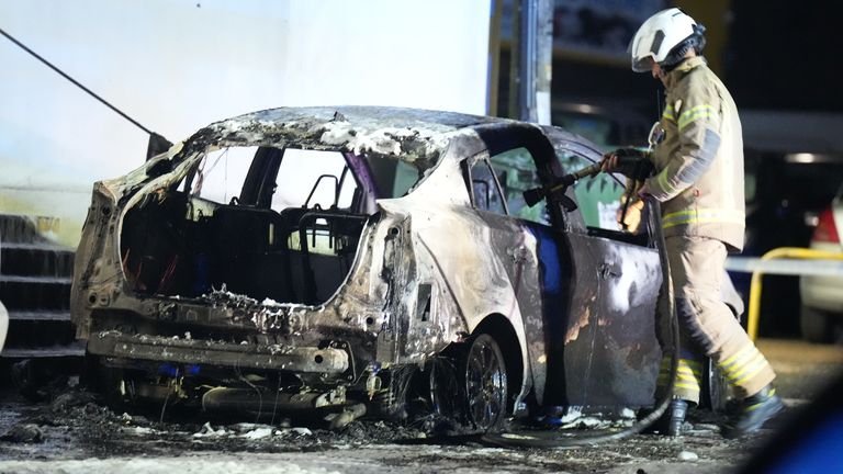 The burnt-out car in front of the mosque. Pic: Eddie Mitchell