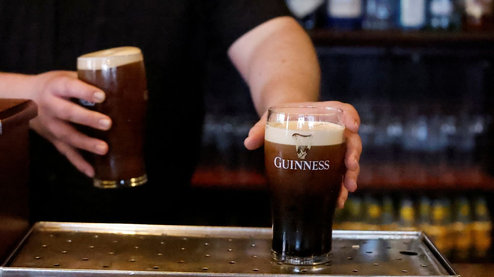 A bartender placing pints of Guinness on the counter at a pub in Dublin. Pic: Reuters