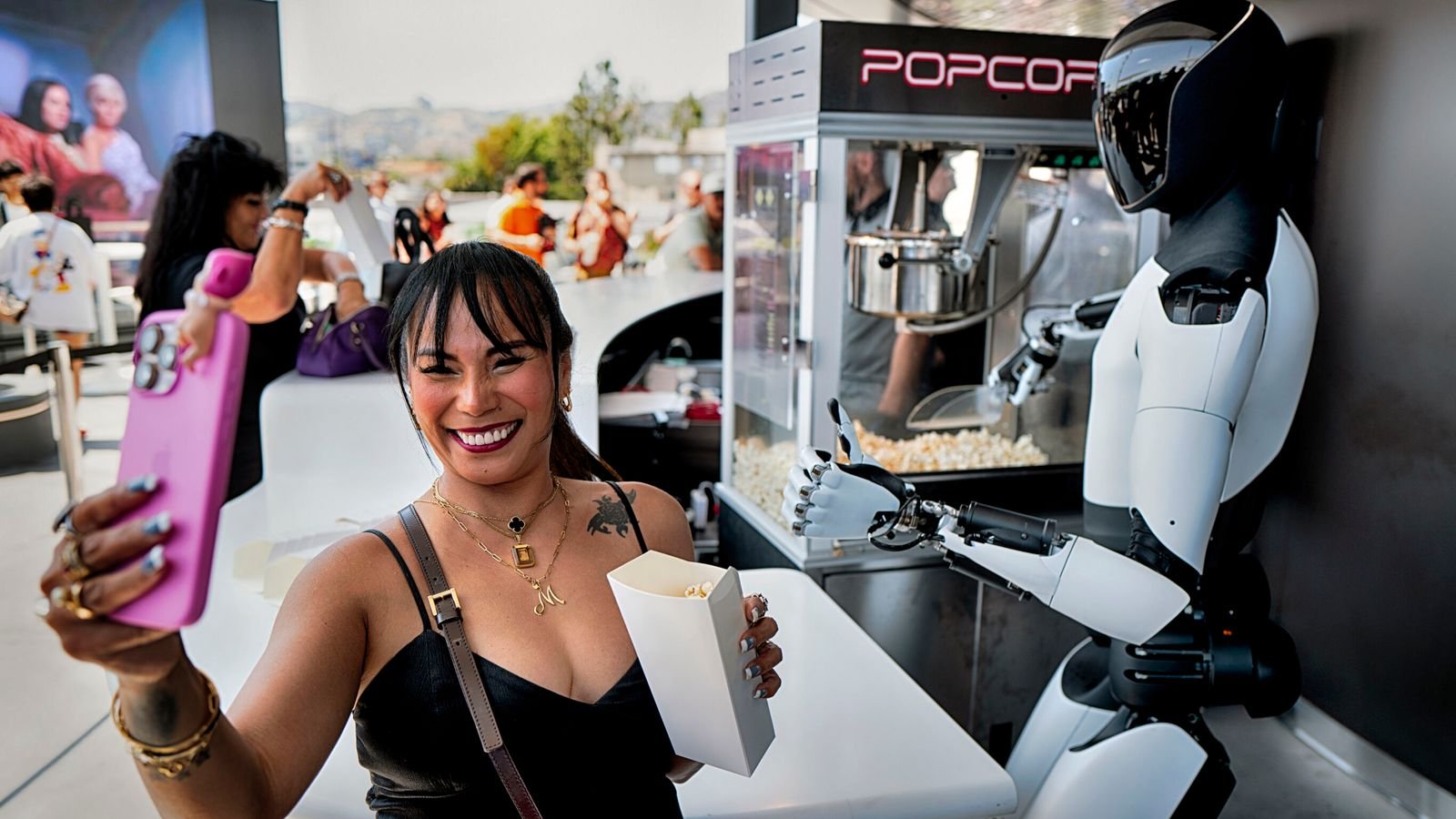 An Optimus robot serving popcorn at the Tesla Diner in Los Angeles. Pic: AP/Richard Vogel