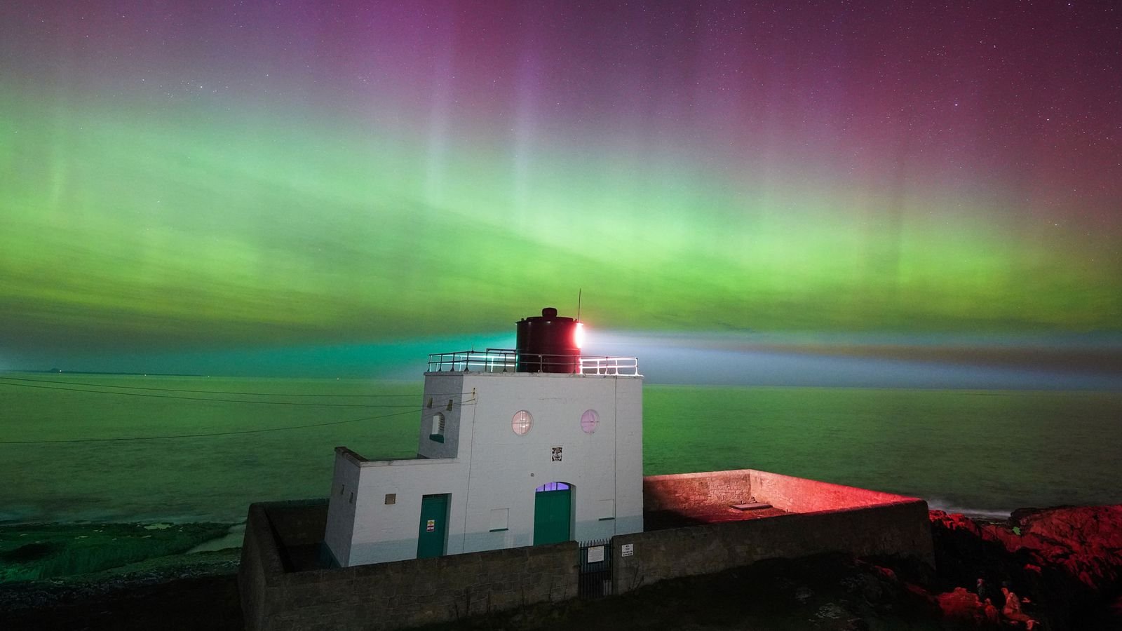 The aurora borealis above Bamburgh Lighthouse in Northumberland. Pic: PA