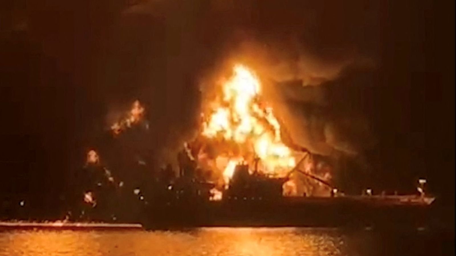 A ship is illuminated by fire after Iranian attacks on fuel tankers in Iraq. Pic: Reuters